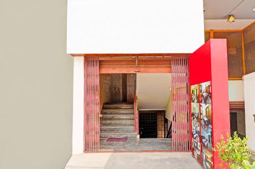 a stairway leading into a building with red and white walls at Super Hotel O Srigandhakavalu formerly Chamundeshwari Lodging in Bengaluru