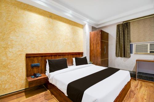 a bedroom with a large bed and a television at Hotel O Prayagraj Junction Civil Line Formerly Station View in Civil Lines