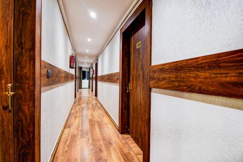 an empty hallway with wooden floors and doors at Hotel O Prayagraj Junction Civil Line Formerly Station View in Civil Lines