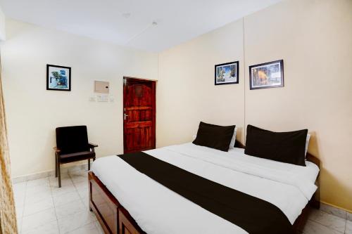 a bedroom with a large bed and a chair at Super Townhouse Calangute Formerly Hotel Horizon in Goa