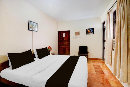 a bedroom with a large white bed with black pillows at Super Townhouse Calangute Formerly Hotel Horizon in Goa