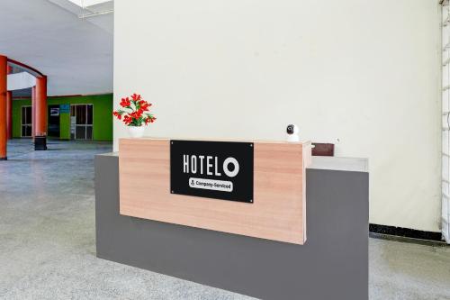 a hotel sign on a reception desk in a room at Super Hotel O Hennagara Rd Bommasandara in Bengaluru
