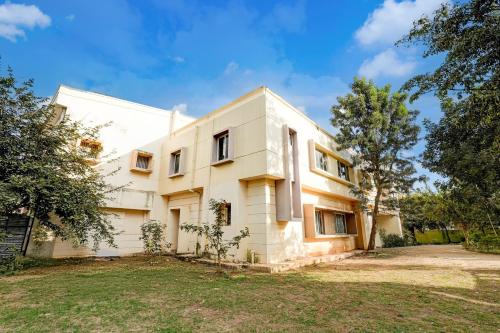 an exterior view of a white house at Super Hotel O Hennagara Rd Bommasandara in Bengaluru