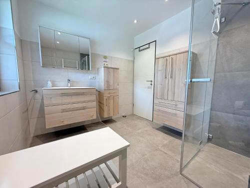 a bathroom with a shower and a sink and a mirror at FeWo Zuhause Ruhpolding in Ruhpolding