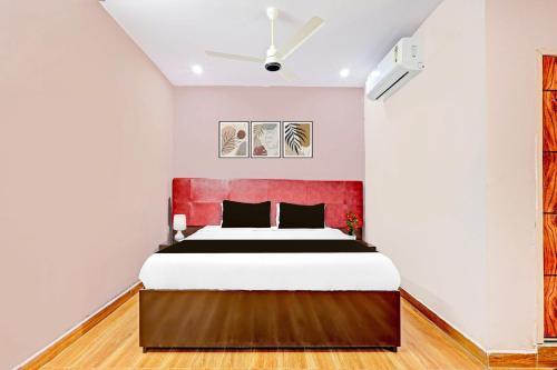 a bedroom with a bed with a red headboard at Super Hotel O Ramarvapadu Near ESI Hospital in Vijayawada