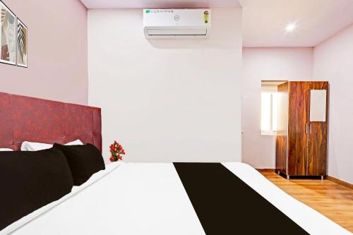 a bedroom with a black and white bed and a heater at Super Hotel O Ramarvapadu Near ESI Hospital in Vijayawada
