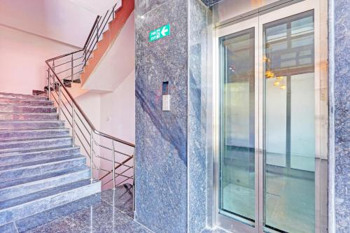 a staircase in a building with a exit sign on the wall at Super Hotel O Ramarvapadu Near ESI Hospital in Vijayawada