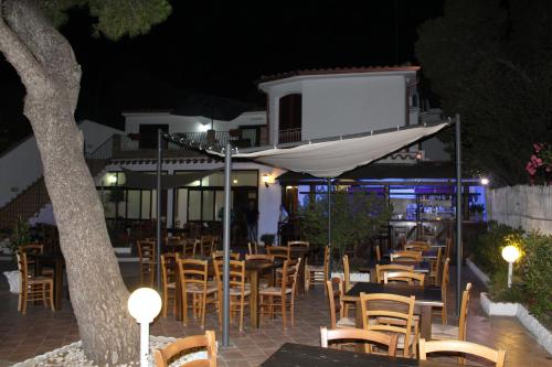 a row of tables and chairs at a restaurant at night at Affittacamere la Medusa in Porto Pino