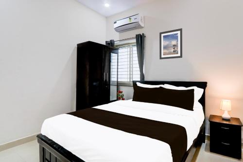 a bedroom with a black and white bed and a window at Super Hotel O Adibatla near TCS in Hyderabad