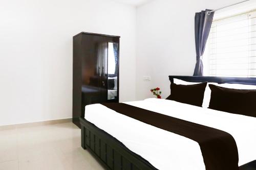a bedroom with a large black and white bed at Super Hotel O Adibatla near TCS in Hyderabad