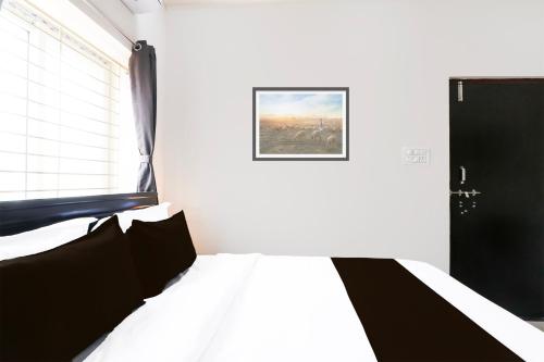 a bedroom with a bed and a picture on the wall at Super Hotel O Adibatla near TCS in Hyderabad