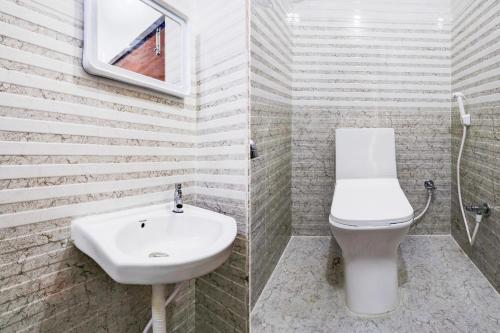 a bathroom with a white sink and a toilet at Super Hotel O Adibatla near TCS in Hyderabad
