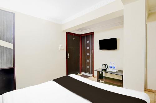 a hotel room with a bed and a television at Super Hotel O Sarat Bose Road formerly Shree Guest House in Kolkata