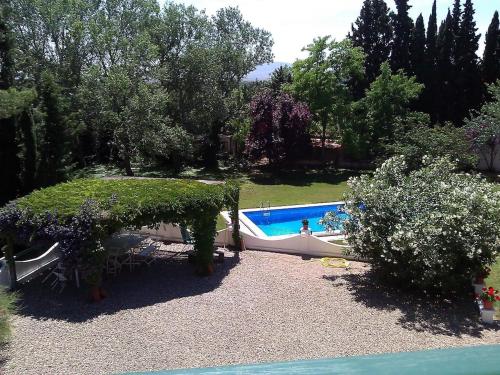 a garden with a swimming pool and trees at Dehesa de San Juan in Milagro