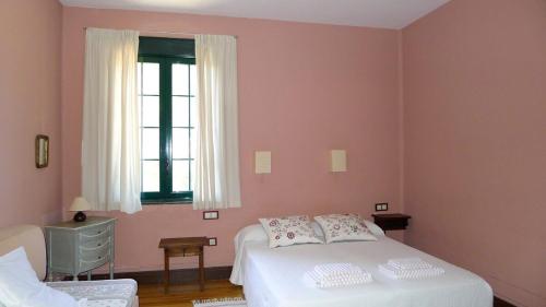 a bedroom with a white bed and a window at Dehesa de San Juan in Milagro