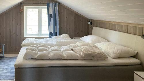 a bedroom with two beds with white blankets and pillows at Cabin With Panoramic Views Over The Mountains in Nesbyen