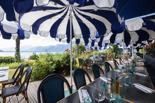 a table with blue and white umbrellas at a restaurant at La Villa in Montreux