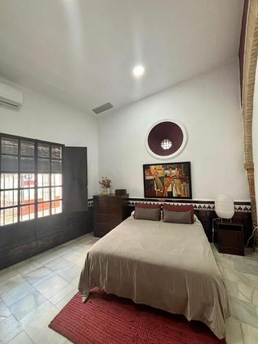 a bedroom with a large bed and a red rug at Casona La Fábrica in Villalba del Alcor