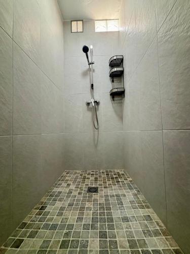 a bathroom with a shower and a tiled floor at Casona La Fábrica in Villalba del Alcor