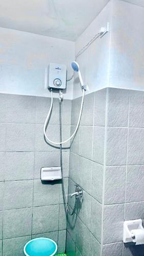 a shower in a bathroom with a blue toilet at Messatiera Condo - UrbanSol Stay in Davao City