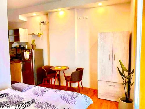 a room with a bed and a table and a kitchen at Messatiera Condo - UrbanSol Stay in Davao City