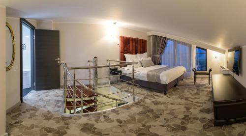 a hotel room with a bed and a glass staircase at HOTEL CARPAT INN in Azuga