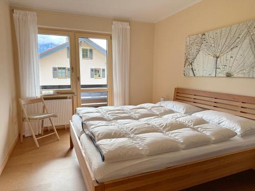 a bedroom with a large bed and a window at FeWo Zuhause Ruhpolding in Ruhpolding