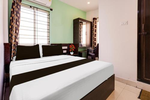 a bedroom with a large bed in a room at Super Hotel O Guntur in Guntūr
