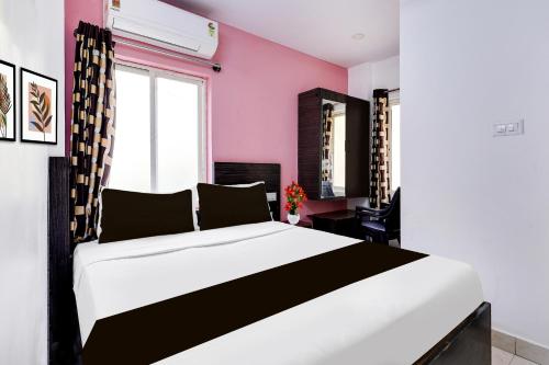 a bedroom with a black and white bed and a window at Super Hotel O Guntur in Guntūr