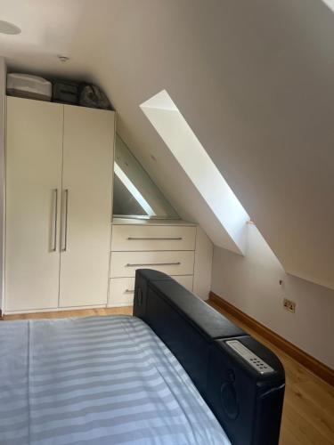 a attic bedroom with a bed and a skylight at Turnhams Gill located near high street in Henfield