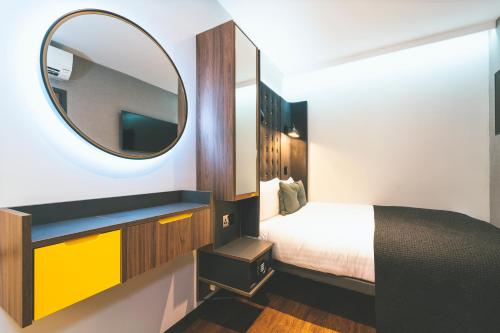 a small bedroom with a bed and a mirror at Point A London Liverpool Street in London