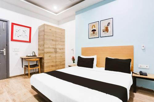 a bedroom with a large bed and a desk at Super Townhouse Rohini Sector 23 in New Delhi