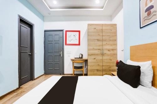 a bedroom with a large bed and a desk at Super Townhouse Rohini Sector 23 in New Delhi