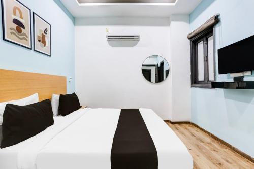 a bedroom with a bed and a tv on the wall at Super Townhouse Rohini Sector 23 in New Delhi