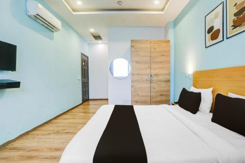 a bedroom with a large bed and a television at Super Townhouse Rohini Sector 23 in New Delhi