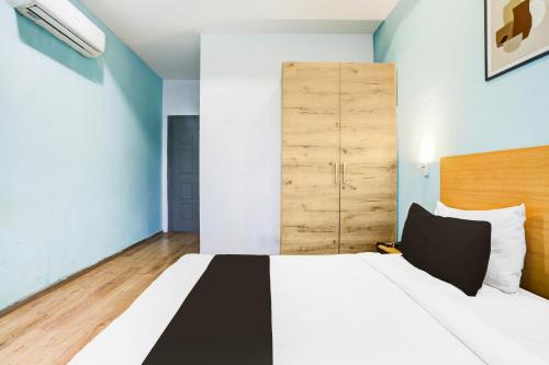 a bedroom with a large bed with a wooden headboard at Super Townhouse Rohini Sector 23 in New Delhi