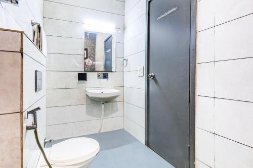 a bathroom with a toilet and a sink at Super Townhouse Rohini Sector 23 in New Delhi