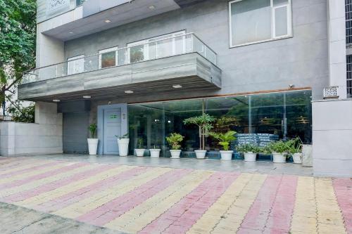 a building with a balcony with potted plants on it at Super Townhouse Rohini Sector 23 in New Delhi