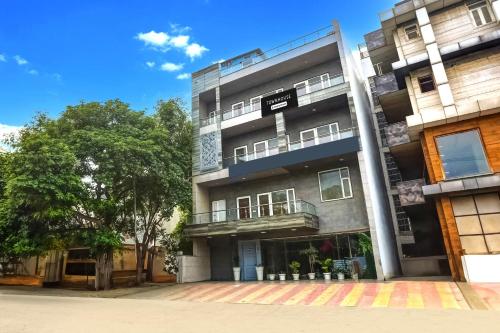an apartment building with a tree in front of it at Super Townhouse Rohini Sector 23 in New Delhi