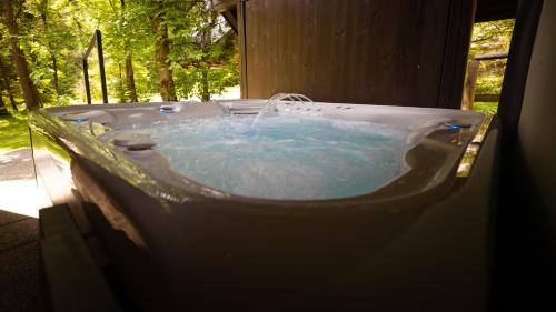 a bath tub with a water fountain in it at Chalet Lana with Hot Tub in Gozd Martuljek