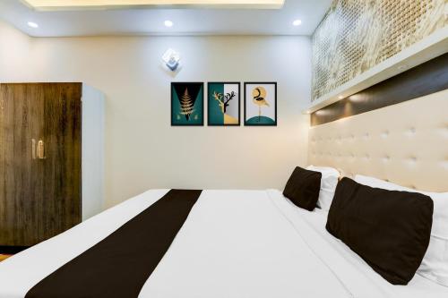 a bedroom with a large white bed with black pillows at Super Collection O Jagdeo Path Patna in Patna