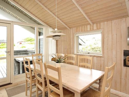 a dining room with a wooden table and chairs at Modern Beach Retreat - By Traum Ferienwohnungen in Løkken