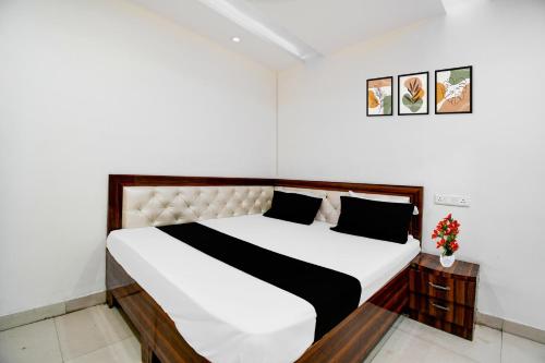 a bedroom with a white bed with a black and white comforter at Super Hotel O Gorakhpur Industrial Area Formerly Shaurya Inn in Pipra