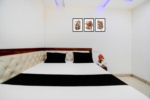 a bedroom with a large white bed with black pillows at Super Hotel O Gorakhpur Industrial Area Formerly Shaurya Inn in Pipra