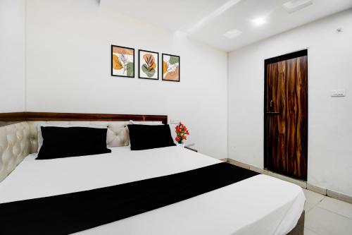 a bedroom with a large white bed and a door at Super Hotel O Gorakhpur Industrial Area Formerly Shaurya Inn in Pipra