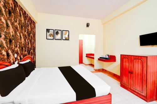 a bedroom with a bed and a tv on a wall at Super Townhouse Mysore Central Formerly Olive Star in Mysore
