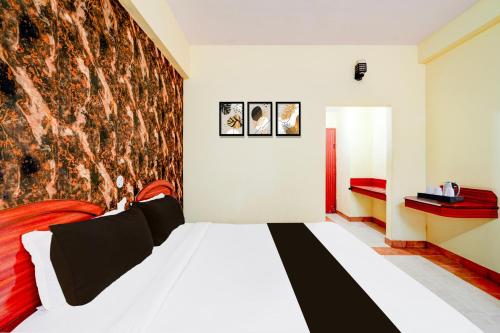 a bedroom with a bed with a large wall at Super Townhouse Mysore Central Formerly Olive Star in Mysore