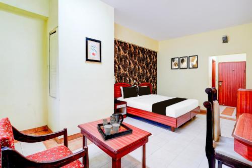 a bedroom with a bed and a table and chairs at Super Townhouse Mysore Central Formerly Olive Star in Mysore