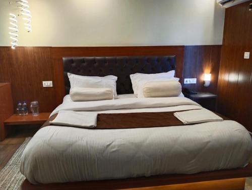a bedroom with a large bed with a black headboard at Iceberg Hill View in Mussoorie