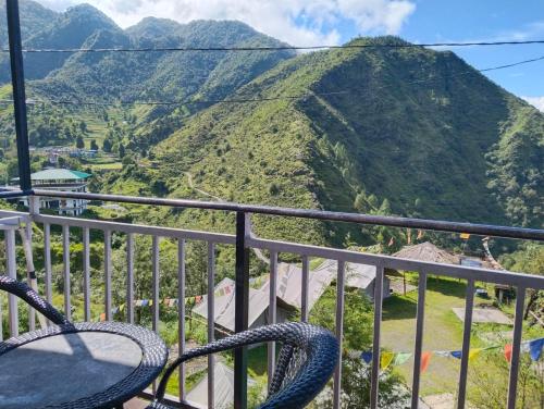 a balcony with chairs and a view of a mountain at Iceberg Hill View in Mussoorie